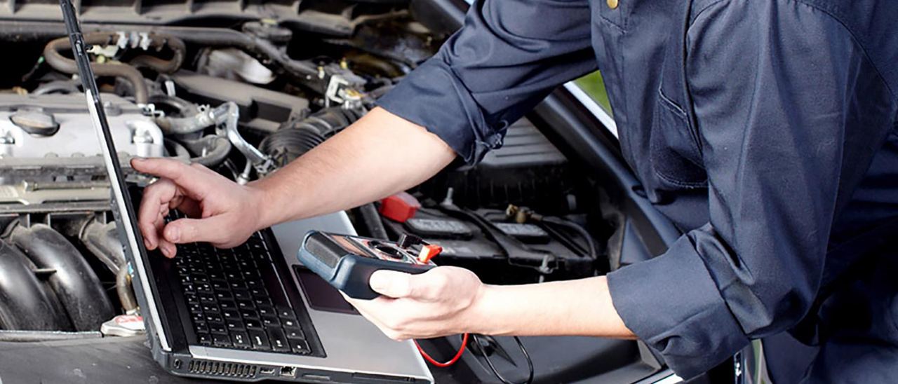 elettrauto al lavoro sul quadro elettrico dell'auto